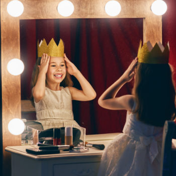 Cute little actress. Cute little actress. Child girl in Princess costume on the background of theatrical scenes and mirrors.